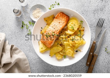 Salmon grilled and baked potato with onions, top down view