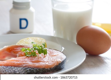 Salmon, milk, eggs and cheese, in background vitamin D. Natural sources of vitamin D and supplement 