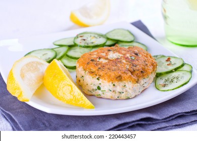 Salmon Patty Served With Lemon And Cucumber