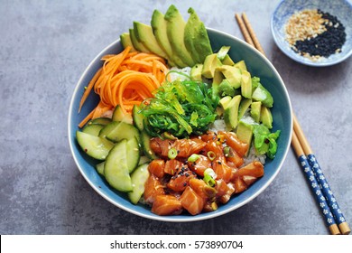 Salmon poke with avocado, seaweed, pickled carrots and cucumber - Shutterstock ID 573890704