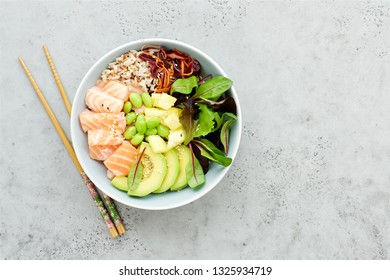 Salmon Poke Bowl With Salad, Avocado, Edamame Beans, Pineapple And Sesame Brown Rice Poke Bowl Top View, Clean Eating Concept Traditional Hawaiian Dish