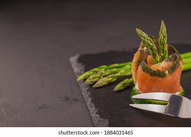 Salmon roll with cream cheese and asparagus isolated in black ba - Powered by Shutterstock