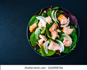 Salmon Salad - Roasted Salmon And Vegetable Leaves On Black Stone Background