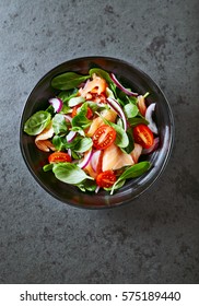 Salmon Salad with spinach, cherry tomatoes, corn salad, baby spinach, fresh mint and basil. Home made food. Concept for a tasty and healthy meal. Dark stone background. Top view. Copy space. - Shutterstock ID 575189440