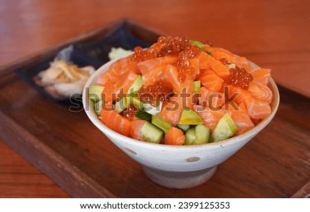 Salmon Sashimi Bowl (Donburi), selective focus. Salmon Sashimi Bowl, Steamed Japanese rice topped with fresh sashimi-grade salmon, briny salmon roe (ikura), and avocado
