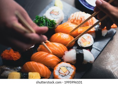 Salmon Sashimi in Japanese buffet restaurant menu.Fresh salmon sushi.Asian friends people using chopsticks  eating sashimi sushi set Japan in restaurant.Asian Food Menu.seafood sashimi.People and food - Powered by Shutterstock