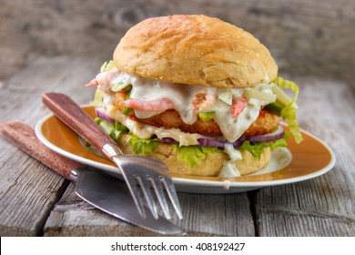 Salmon And Shrimp Burger , Mayonnaise On Bottom Bun , Breaded Salmon Shrimp Patty And Tartar Sauce With Fresh Shrimps On Gray Wooden Boards Background