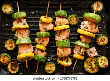 Salmon skewers with zucchini in herbal marinade in a grill pan top view