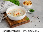 Salmon soup with cream, potatoes, carrots, herb and croutons in a bowl on a gray concrete background. Copy space