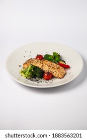 Salmon Steak, Combined With Fried Broccoli In Butter, With Baked Cherry Tomatoes And Cream Sauce, On A White Background