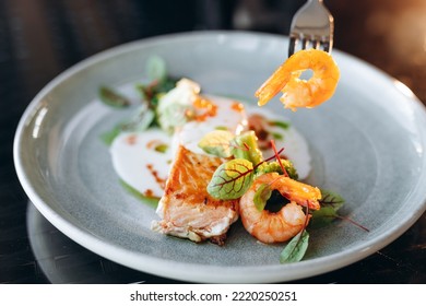 Salmon Steak Covered In Cream Sauce, Garnished With Shrimp And Red Caviar. Restaurant Service.