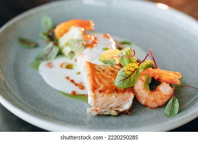 Salmon Steak Covered In Cream Sauce, Garnished With Shrimp And Red Caviar. Restaurant Service.