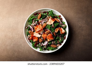 Salmon superfood salad with grilled fish, kale, quinoa, pecan nuts, red onion and pomegranate. Top view - Powered by Shutterstock