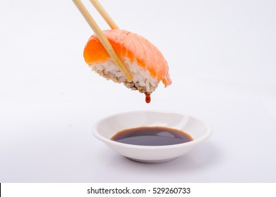 salmon sushi keep chopsticks and dipped into the sauce - Powered by Shutterstock