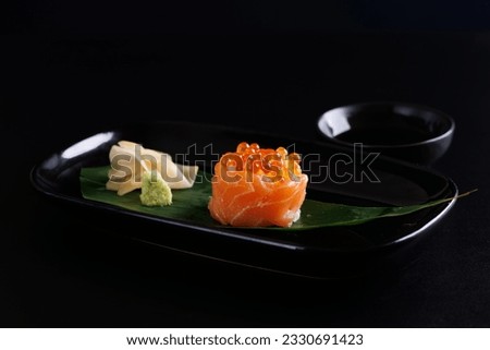 Salmon Sushi roll with caviar topping Japanese food isolated in black background