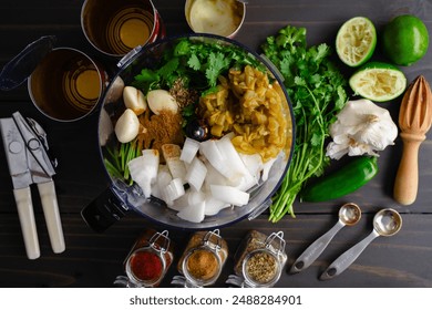 Salsa Ingredients in a Food Processor Before Blending: Chopped onions, garlic cloves, and cilantro with canned green chiles, tomatoes, and spices - Powered by Shutterstock