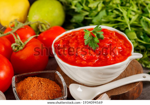 Salsa Sauce.\
Spicy, colorful Mexican salsa sauce with hot peppers and tomatoes\
on a dark background.Classic homemade Italian tomato sauce  for\
pasta  pizza in  on wooden\
background.
