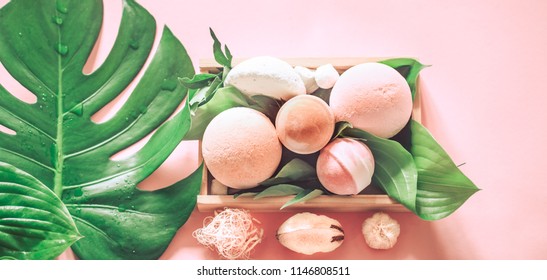 salt bombs for a spa bath still life on a colored background with tropical real leaves