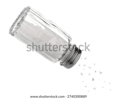 Salt falling down from shaker on white background