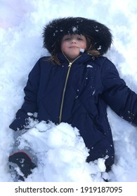 Salt Lake City, Utah, U.S.A. - February 17th 2021: Young Girl Playing Outdoors In A Pile Of Snow Which Has Fallen Over Night And In The Early Morning, Due To Inclement Weather It Became A Snow Day.