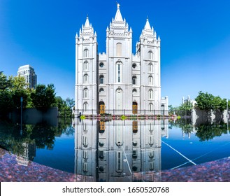 salt lake LDS mormon temple mirrored in the pond on a sunny day with blue sky no clouds