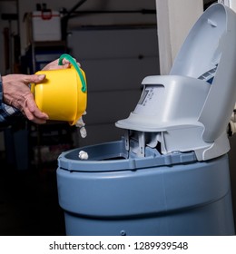 Salt pellets are added to the reservoir of a water softener 