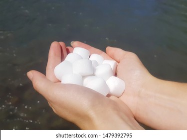 Salt pellets for the water softener in female hands.