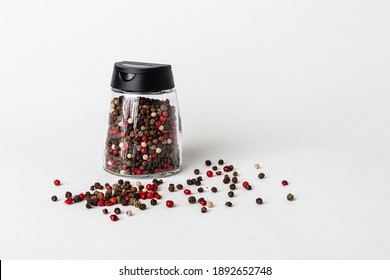Salt and pepper grinders. Dried whole seed of black pepper and white coarse sea salt isolated on a white background seen from above. 
