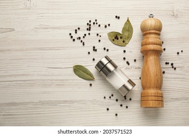 Salt and pepper shakers with bay leaves on white wooden table, flat lay. Space for text - Powered by Shutterstock