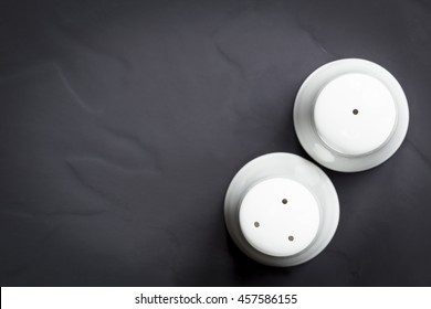 Salt And Pepper Shakers On Dark Slate.  Top View.