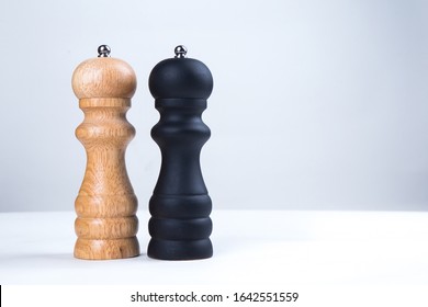 salt and pepper wooden shakers, grinders on a white table with white background  - Powered by Shutterstock