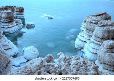 Salt pillars, Dead Sea coast. Beautiful bay with salt ledges. Sunrise, calm water. The concept of chopping the dead sea, nature, tranquility, travel, peaceful mood. Nobody. Sunrise.