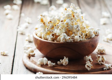 Salt popcorn on the wooden table, selective focus