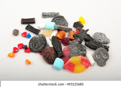 Salt, Sour And Sweet Candy Spread Out On White Background. Super Salt Skulls, Sweet Hearts And Jaw Breakers. Colorful Candy Shot From Above.