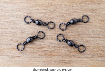 Salt Water Swivels For Fishing On A Wood Background.