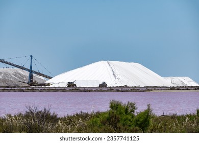 Salt works, industrial plant with white piles of Camagrue sea salt and pink salty lakes, Aigues-Mortes, Gard, Occitania region of southern France