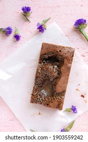 Salted Caramel Brownie On Pink Surface With Purple Flowers