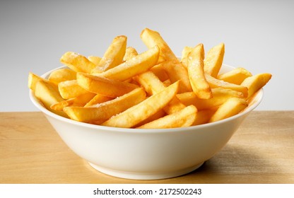 Salted French fries in white bowl on a wooden tray - Powered by Shutterstock