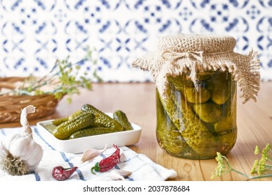 Salted pickled cucumbers preserved canned in glass jar. Plate of pickled homemade gherkins with fresh dill. Autumn vegetables canning. Healthy homemade food.