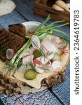 Salted planed bacon with green onions, pickles, horseradish and mustard. With rye bread. Served on a wooden saw, on a wooden table background. Rustic style. Appetizer with vodka and tincture