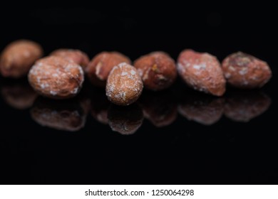 Salted roasted peanuts close up macro shot on shiny black surface, space for text. - Powered by Shutterstock