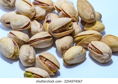 Salted roasted pistachio nuts on a white background - Shutterstock ID 2254374367