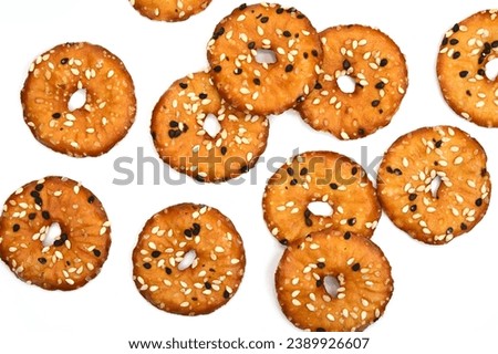 Salted round pretzels with black and white sesame isolated on white. Cracker chips with sea salt isolated on white background. Round shape appetizers. Salty crackers with sesame isolated 