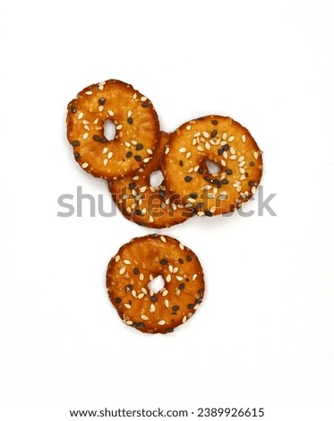 Salted round pretzels with black and white sesame isolated on white. Cracker chips with sea salt isolated on white background. Round shape appetizers. Salty crackers with sesame isolated 