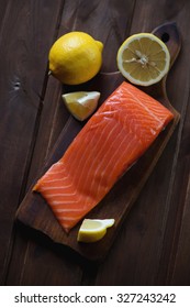 Salted Trout Filet With Lemon On A Dark Rustic Wooden Background, View From Above