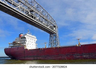  a saltie freighter from quebec passes  under the aerial lift bridge from lake superior into duluth harbor  on a sunny fall day in duluth, minnesota 