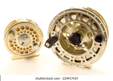 A Saltwater And A Freshwater Fly Fishing Reel On A White Background.