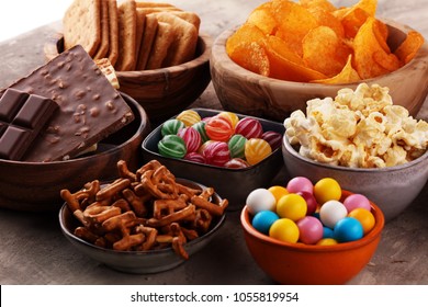 Salty snacks. Pretzels, chips, crackers in wooden bowls. Unhealthy products. food bad for figure, skin, heart and teeth. Assortment of fast carbohydrates food. 