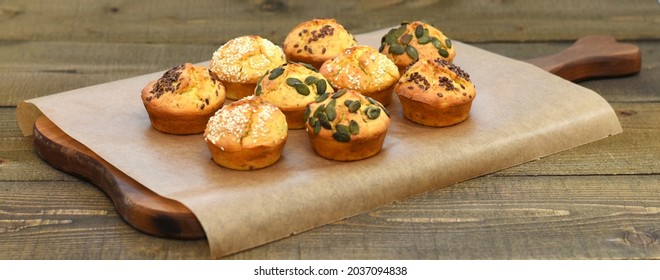 Salty and tasty muffins, baked and decorated with seeds toper placed on the wooden table, bakery ideas 
