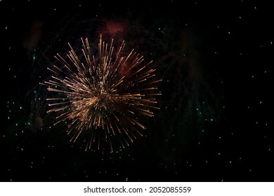 Salute in the sky. Explosion of fireworks in the night sky. Firecrackers flapping sparks in a dark space. Festive fireworks. Background with sparks from burning gunpowder.